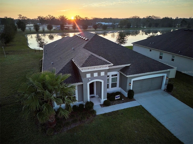 1817 Westerham Ave, Saint Cloud, FL 34771 - view of front of home with a water view, an attached garage, concrete driveway, a shingled roof, and stucco siding