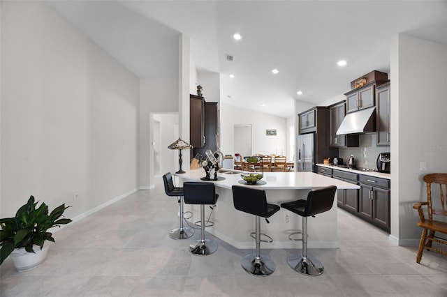 2000 Goblet Cove St, Kissimmee, FL 34746 - kitchen featuring under cabinet range hood, a breakfast bar area, stainless steel fridge with ice dispenser, a peninsula, and light countertops