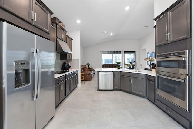 2000 Goblet Cove St, Kissimmee, FL 34746 - kitchen featuring appliances with stainless steel finishes, under cabinet range hood, lofted ceiling, dark brown cabinetry, and light countertops