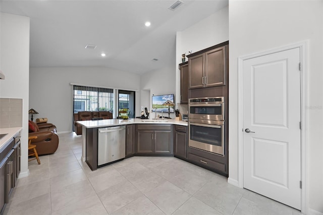 2000 Goblet Cove St, Kissimmee, FL 34746 - kitchen with stainless steel appliances, open floor plan, vaulted ceiling, a peninsula, and light countertops