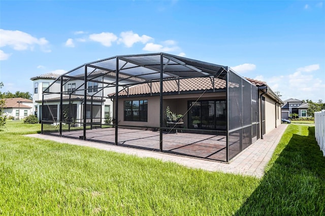 2000 Goblet Cove St, Kissimmee, FL 34746 - back of property with a lawn, a patio area, glass enclosure, stucco siding, and a tile roof