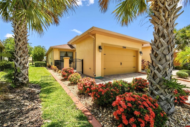 3390 Fallbrook Dr, Kissimmee, FL 34759 - view of front of property with stucco siding, an attached garage, and driveway