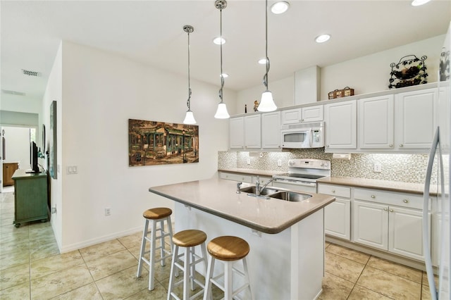 3390 Fallbrook Dr, Kissimmee, FL 34759 - kitchen with white appliances, tasteful backsplash, white cabinetry, light tile patterned floors, and recessed lighting