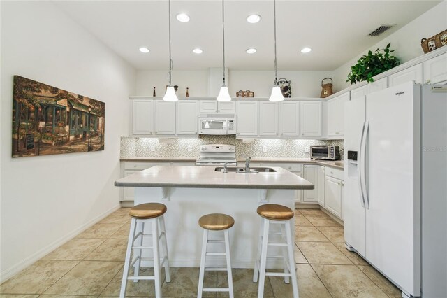 3390 Fallbrook Dr, Kissimmee, FL 34759 - kitchen with white appliances, tasteful backsplash, light tile patterned flooring, light countertops, and white cabinetry