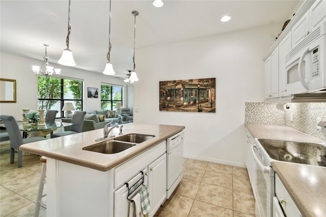 3390 Fallbrook Dr, Kissimmee, FL 34759 - kitchen with white appliances, a chandelier, decorative backsplash, white cabinetry, and recessed lighting