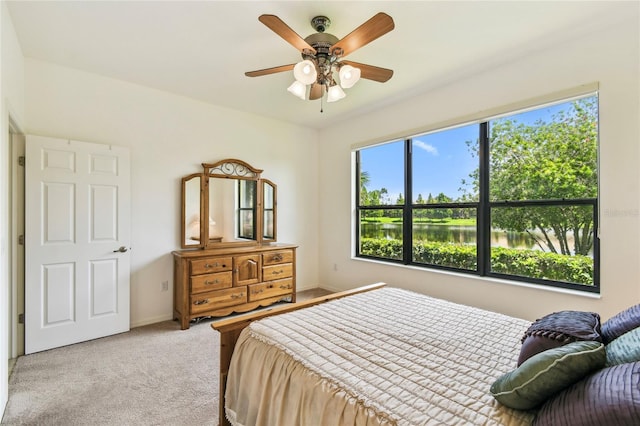 3390 Fallbrook Dr, Kissimmee, FL 34759 - bedroom with light carpet, a water view, and a ceiling fan