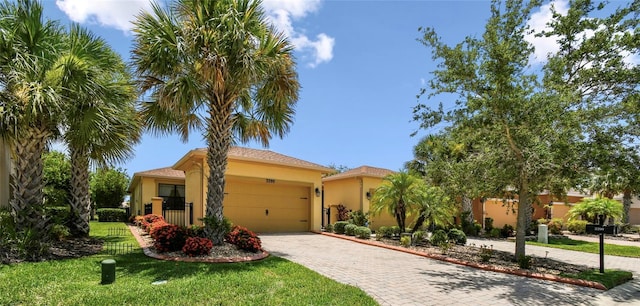 3390 Fallbrook Dr, Kissimmee, FL 34759 - view of front of property with stucco siding, decorative driveway, a garage, and a front yard