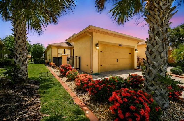 3390 Fallbrook Dr, Kissimmee, FL 34759 - view of side of home featuring stucco siding, an attached garage, and driveway