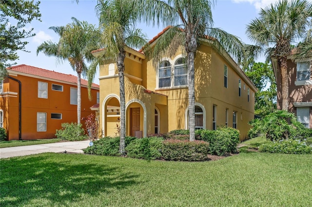 143 Tiger Lily Ct, Davenport, FL 33837 - mediterranean / spanish house featuring concrete driveway, stucco siding, a front lawn, and a garage