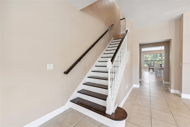 143 Tiger Lily Ct, Davenport, FL 33837 - staircase featuring tile patterned floors and baseboards