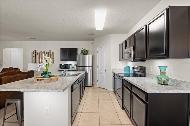 555 Lucerne Blvd, Winter Haven, FL 33881 - kitchen featuring appliances with stainless steel finishes, light countertops, a kitchen breakfast bar, light tile patterned floors, and a textured ceiling