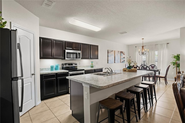 555 Lucerne Blvd, Winter Haven, FL 33881 - kitchen featuring stainless steel appliances, light tile patterned floors, light countertops, a chandelier, and a textured ceiling