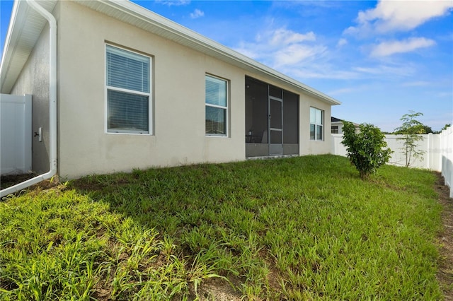 555 Lucerne Blvd, Winter Haven, FL 33881 - rear view of property featuring a fenced backyard, a sunroom, and stucco siding