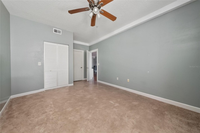 5548 Metrowest Blvd Unit 202, Orlando, FL 32811 - unfurnished bedroom featuring a textured ceiling, light carpet, a ceiling fan, and a closet