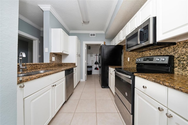5548 Metrowest Blvd Unit 202, Orlando, FL 32811 - kitchen featuring stainless steel appliances, tasteful backsplash, white cabinetry, light tile patterned floors, and crown molding