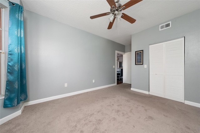 5548 Metrowest Blvd Unit 202, Orlando, FL 32811 - unfurnished bedroom featuring carpet flooring, a closet, ceiling fan, and a textured ceiling