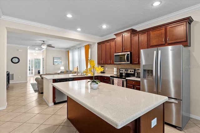 2511 Nouveau Way, Kissimmee, FL 34741 - kitchen with appliances with stainless steel finishes, a peninsula, open floor plan, a center island, and light tile patterned floors