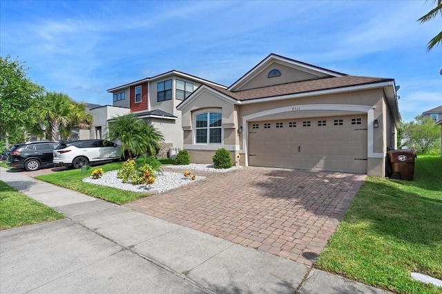 2511 Nouveau Way, Kissimmee, FL 34741 - view of front facade featuring stucco siding, decorative driveway, a garage, and a front lawn