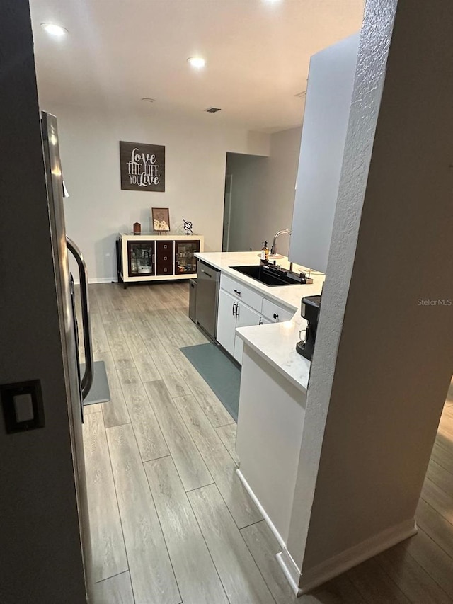 6003 Live Oak Dr, Winter Haven, FL 33880 - kitchen featuring light wood-type flooring, appliances with stainless steel finishes, light countertops, white cabinets, and recessed lighting