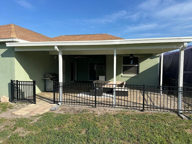 6003 Live Oak Dr, Winter Haven, FL 33880 - back of property with stucco siding, a patio area, and roof with shingles