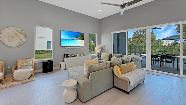 7551 Excitement Dr, Reunion, FL 34747 - living area featuring light wood-style flooring, plenty of natural light, a towering ceiling, ceiling fan, and recessed lighting