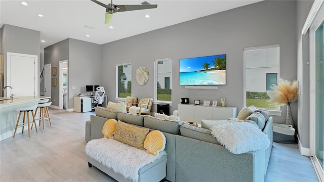 7551 Excitement Dr, Reunion, FL 34747 - living room with light wood-style floors, recessed lighting, a ceiling fan, and a high ceiling
