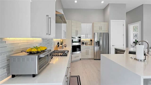 7551 Excitement Dr, Reunion, FL 34747 - kitchen with appliances with stainless steel finishes, wall chimney exhaust hood, light countertops, light wood-type flooring, and recessed lighting
