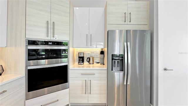7551 Excitement Dr, Reunion, FL 34747 - kitchen with stainless steel appliances, modern cabinets, light countertops, and tasteful backsplash