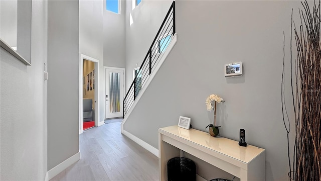 7551 Excitement Dr, Reunion, FL 34747 - hallway featuring light wood-type flooring, a towering ceiling, and stairway
