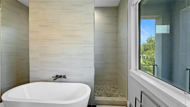 7551 Excitement Dr, Reunion, FL 34747 - full bath with a freestanding bath, tile walls, and a walk in shower