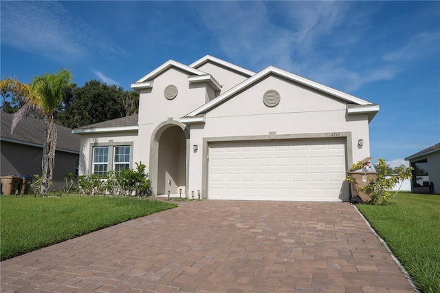 2712 Creekmore Ct, Kissimmee, FL 34746 - view of front of home featuring stucco siding, decorative driveway, a garage, and a front lawn