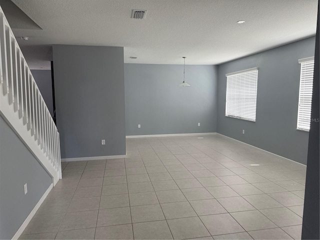 16856 Meadows St, Clermont, FL 34714 - unfurnished room with a textured ceiling, light tile patterned floors, and stairway