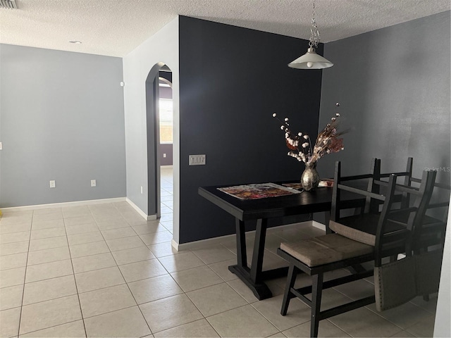 16856 Meadows St, Clermont, FL 34714 - dining space featuring arched walkways, a textured ceiling, and light tile patterned floors