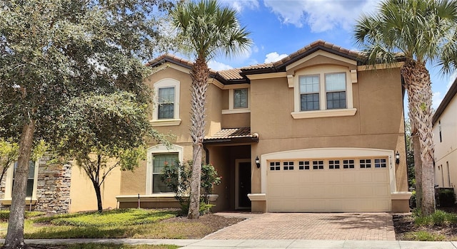 2183 Tripoli Ct, Kissimmee, FL 34747 - mediterranean / spanish-style home featuring a tile roof, stucco siding, an attached garage, and decorative driveway
