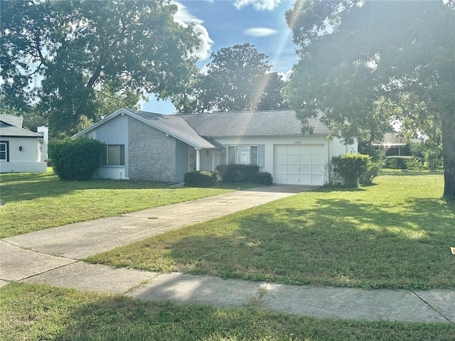 13102 Pembrook Ct, Hudson, FL 34667 - view of front of house featuring an attached garage, concrete driveway, a front yard, and stone siding