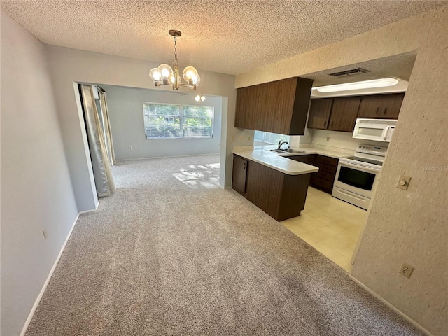 13102 Pembrook Ct, Hudson, FL 34667 - kitchen with white appliances, dark brown cabinets, a chandelier, light countertops, and a textured ceiling