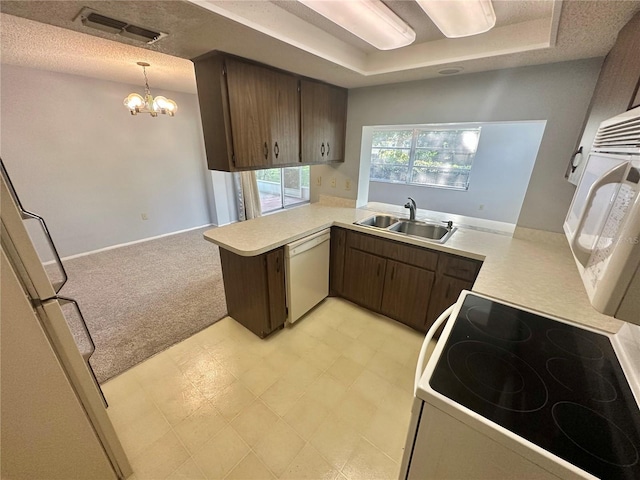 13102 Pembrook Ct, Hudson, FL 34667 - kitchen featuring white appliances, a peninsula, light countertops, a tray ceiling, and a chandelier