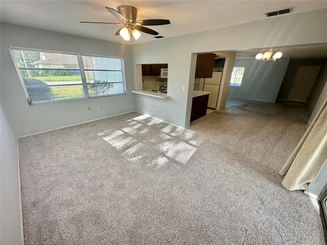 13102 Pembrook Ct, Hudson, FL 34667 - unfurnished living room with ceiling fan, a chandelier, a textured ceiling, and light colored carpet