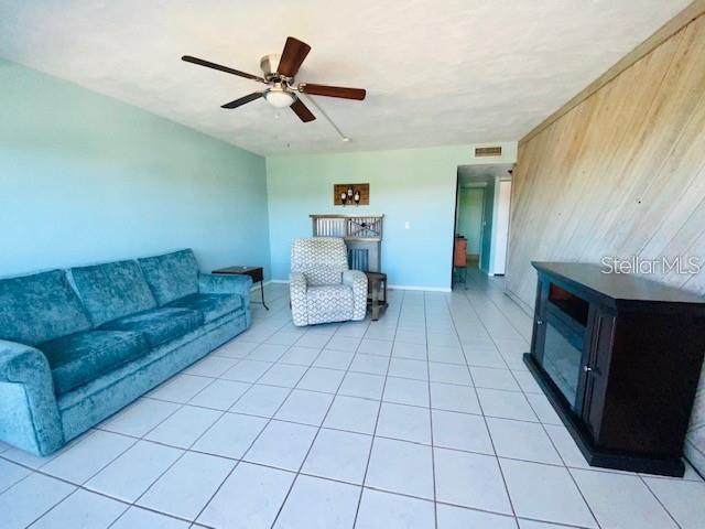 221 Columbia Dr Unit 342, Cape Canaveral, FL 32920 - living area featuring ceiling fan, wooden walls, and light tile patterned floors