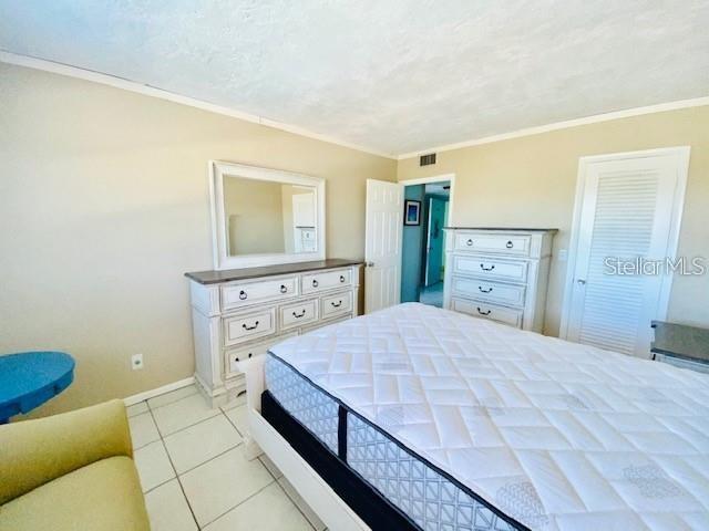 221 Columbia Dr Unit 342, Cape Canaveral, FL 32920 - bedroom featuring ornamental molding and light tile patterned floors