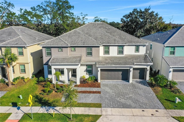 2541 Shanti Dr, Kissimmee, FL 34746 - traditional-style house featuring stucco siding, an attached garage, and decorative driveway