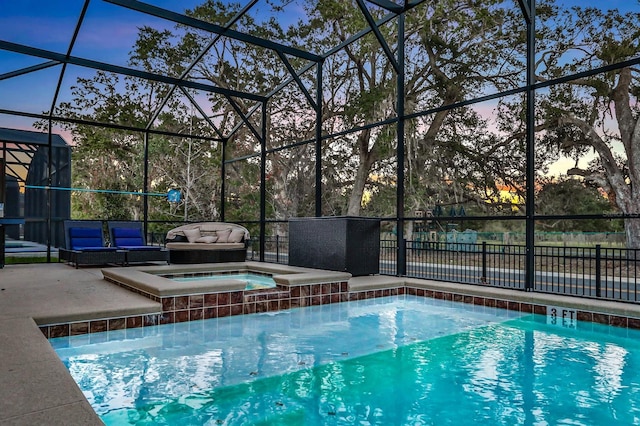 2541 Shanti Dr, Kissimmee, FL 34746 - pool at dusk with a patio, glass enclosure, and a pool with connected hot tub