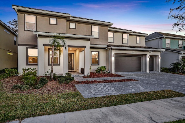 2541 Shanti Dr, Kissimmee, FL 34746 - view of front of home with decorative driveway, a garage, and stucco siding