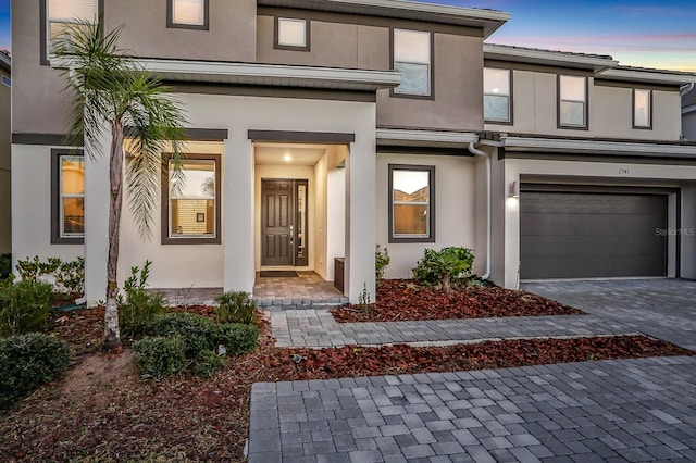 2541 Shanti Dr, Kissimmee, FL 34746 - view of front of house with an attached garage, decorative driveway, and stucco siding
