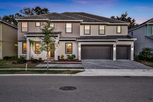 2541 Shanti Dr, Kissimmee, FL 34746 - view of front of home with stucco siding, an attached garage, and decorative driveway