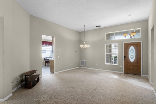 123 Preston Ave, Davenport, FL 33837 - entryway featuring a chandelier, light colored carpet, and a textured ceiling