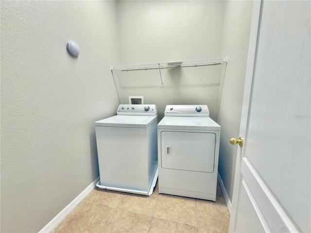 10238 Cala Lily Trl Unit S, Orlando, FL 32832 - laundry area featuring independent washer and dryer, light tile patterned floors, and a textured wall