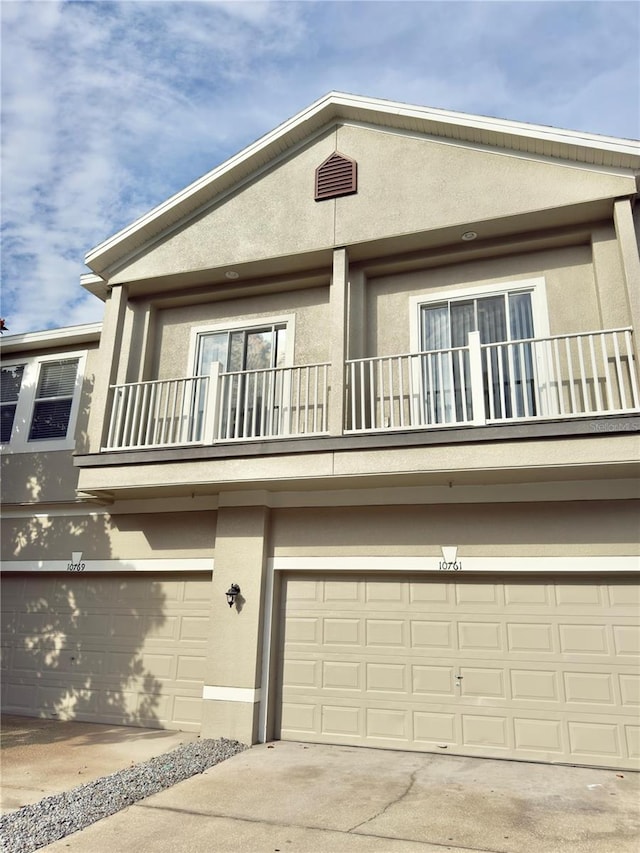 10238 Cala Lily Trl Unit S, Orlando, FL 32832 - view of front of house featuring a balcony, stucco siding, a garage, and driveway