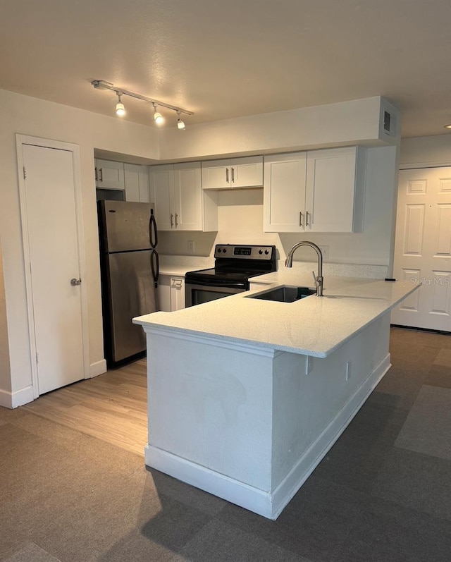 7280 Westpointe Blvd Unit 823, Orlando, FL 32835 - kitchen with a peninsula, appliances with stainless steel finishes, light stone countertops, carpet, and white cabinets