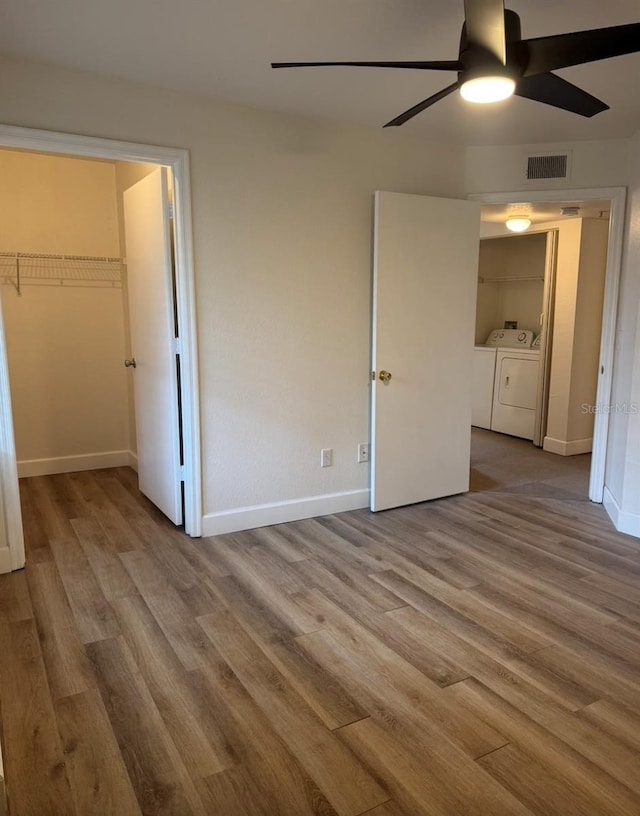 7280 Westpointe Blvd Unit 823, Orlando, FL 32835 - unfurnished bedroom featuring washer and clothes dryer, wood finished floors, and ceiling fan